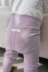 Baby wearing Avauma Aileen Baby Leggings - Cream Purple, high-waist stretchy infant pants, soft ribbed leggings for babies Baby wearing Avauma Aileen Baby Leggings - Cream Purple, high-waist stretchy infant pants, soft ribbed leggings for babies