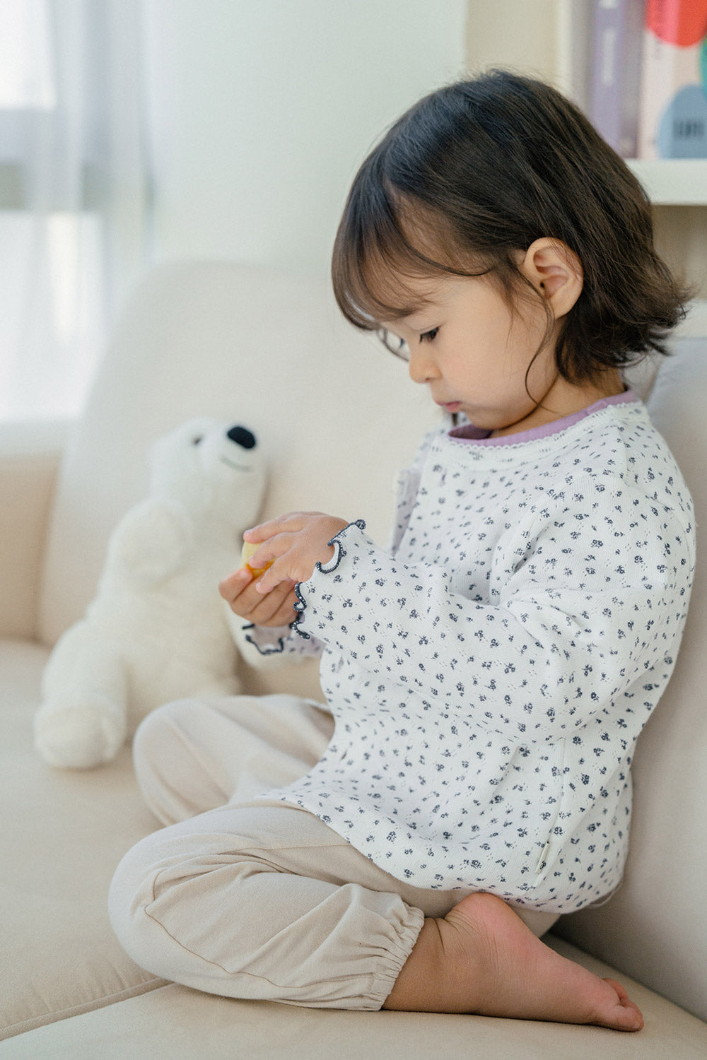 Toddler girl playing in Avauma Aileen Bloom Cardigan – an elegant baby cardigan with a classic navy floral pattern, great for casual and special occasions. Toddler girl playing in Avauma Aileen Bloom Cardigan – an elegant baby cardigan with a classic navy floral pattern, great for casual and special occasions.
