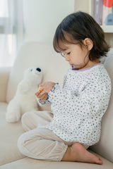 Toddler girl playing in Avauma Aileen Bloom Cardigan – an elegant baby cardigan with a classic navy floral pattern, great for casual and special occasions. Toddler girl playing in Avauma Aileen Bloom Cardigan – an elegant baby cardigan with a classic navy floral pattern, great for casual and special occasions.