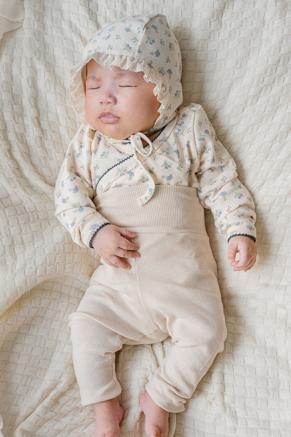 Baby sleeping in the Avauma Cream Bodysuit (Spring Forest print) – showing the breathable fabric, gentle wrap closure, and soothing floral pattern ideal for newborn rest. Baby sleeping in the Avauma Cream Bodysuit (Spring Forest print) – showing the breathable fabric, gentle wrap closure, and soothing floral pattern ideal for newborn rest.
