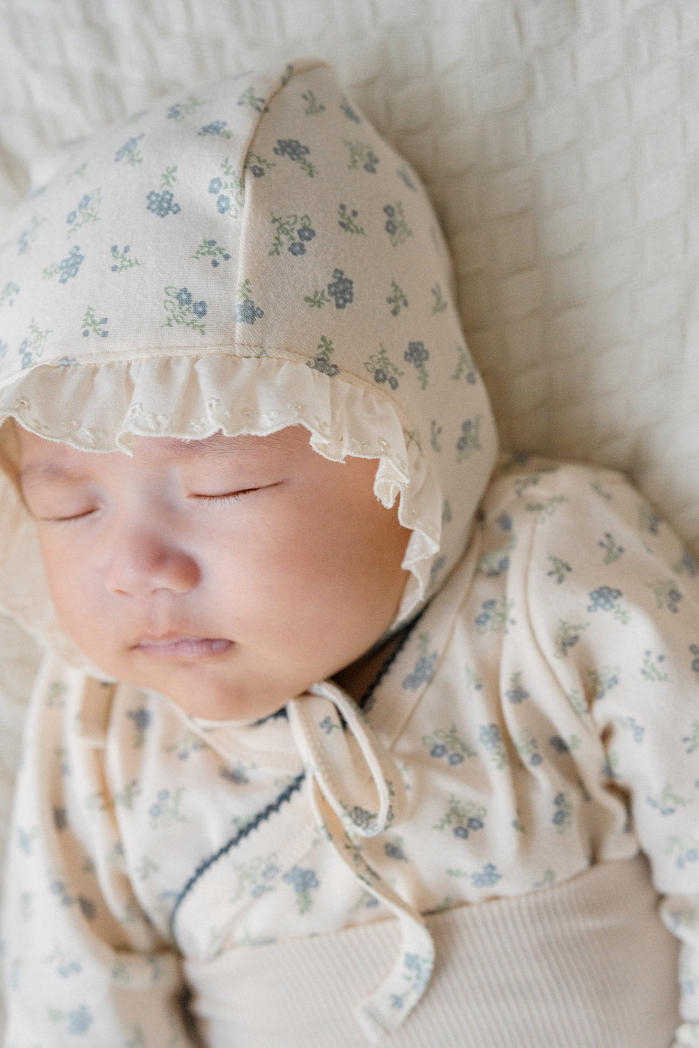 Detailed shot of the matching bonnet and Avauma Cream Bodysuit in Spring Forest print – completing a sweet, coordinated look that enhances comfort and style for infants. Detailed shot of the matching bonnet and Avauma Cream Bodysuit in Spring Forest print – completing a sweet, coordinated look that enhances comfort and style for infants.