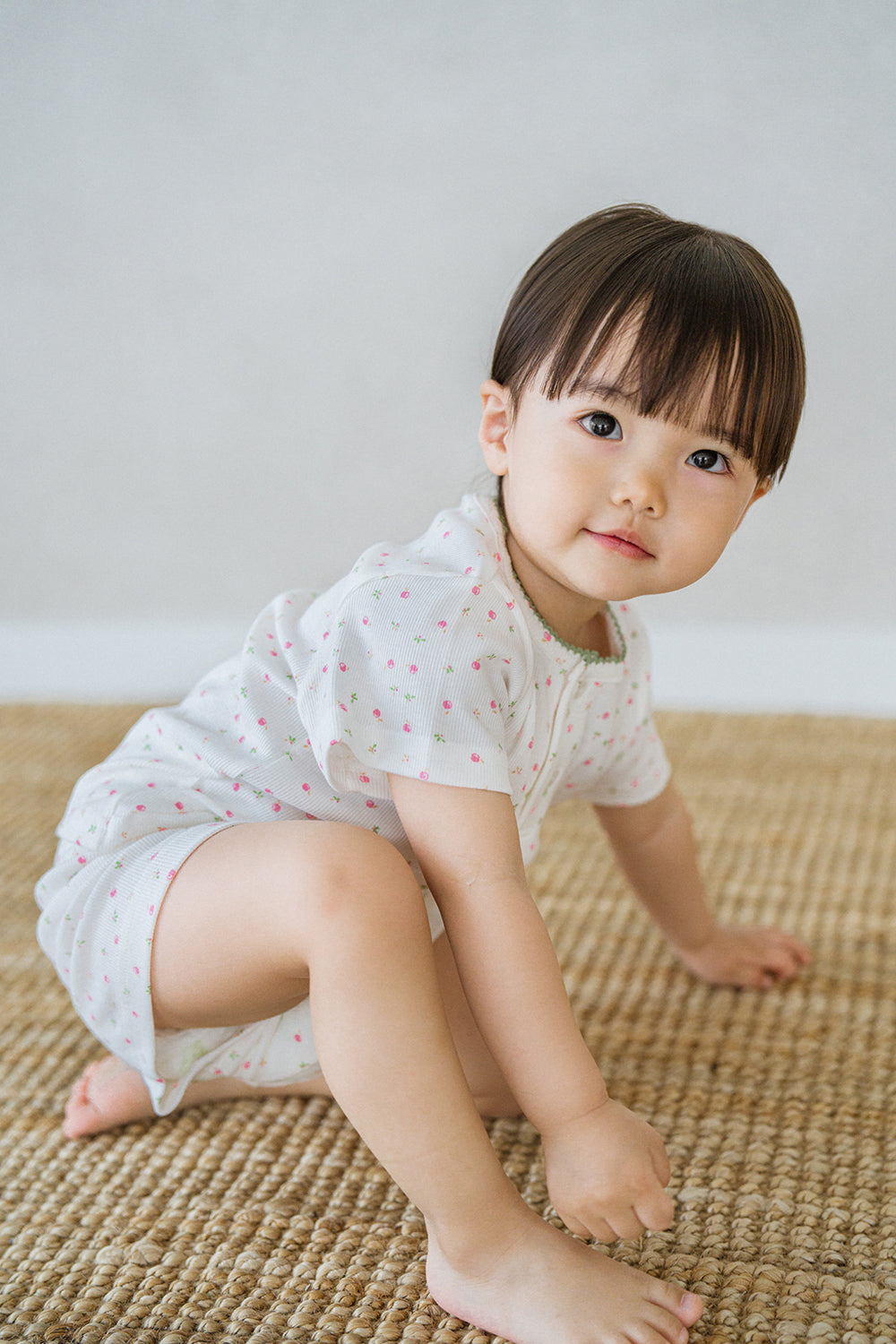 AVAUMA baby girl sitting on floor in sugar berry floral pajama set AVAUMA baby girl sitting on floor in sugar berry floral pajama set