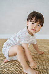 AVAUMA baby girl sitting on floor in sugar berry floral pajama set AVAUMA baby girl sitting on floor in sugar berry floral pajama set