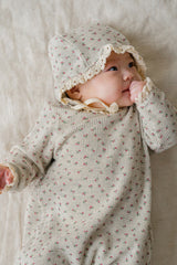 Baby wearing the Mellow Rose bodysuit and bonnet – featuring lace details that add a romantic touch to the floral outfit. Baby wearing the Mellow Rose bodysuit and bonnet – featuring lace details that add a romantic touch to the floral outfit.