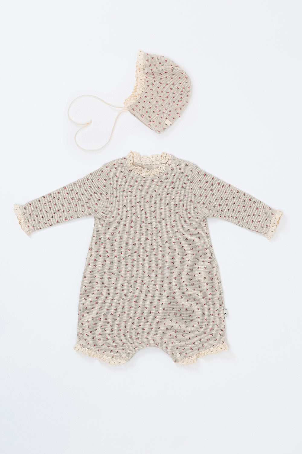 Front view of the Lumiere Bodysuit in Mellow Rose – featuring delicate lace trim and a subtle rose print for babies. Front view of the Lumiere Bodysuit in Mellow Rose – featuring delicate lace trim and a subtle rose print for babies.