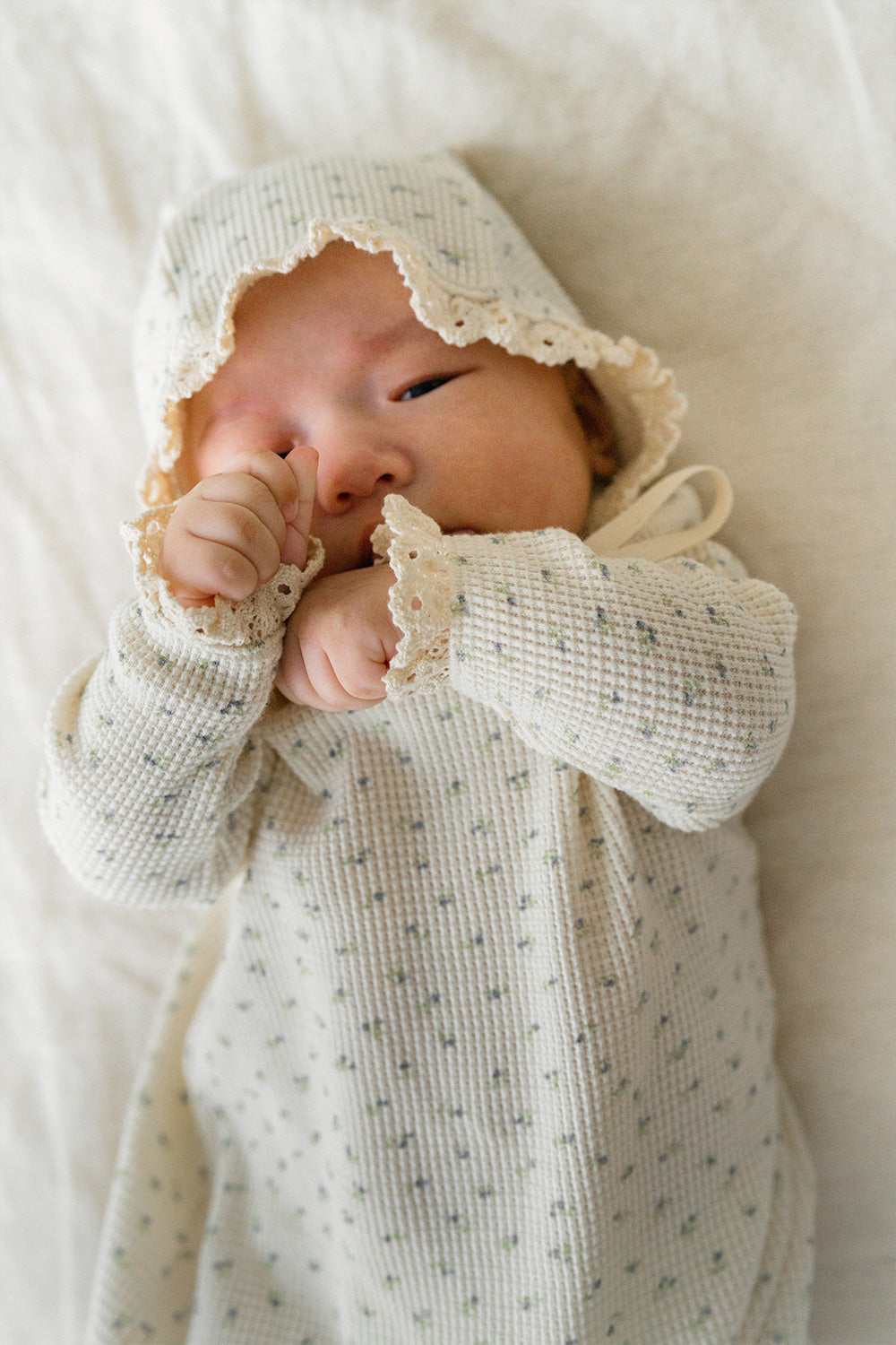 Baby lying down in the Lumiere Classic Blossom Bodysuit – showing a comfortable fit and natural freedom of movement Baby lying down in the Lumiere Classic Blossom Bodysuit – showing a comfortable fit and natural freedom of movement