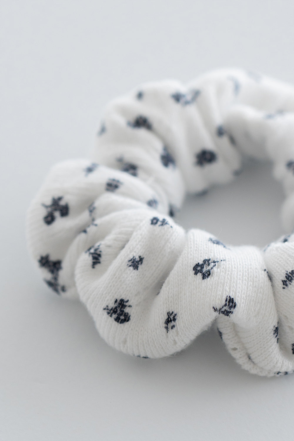 Close-up of white scrunchie with navy indigo floral pattern – Avauma
Close-up of white scrunchie with navy indigo floral pattern – Avauma