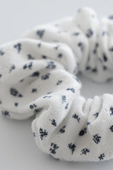 Close-up of indigo whisper scrunchie in white ribbed fabric with navy floral design – Avauma
 Close-up of indigo whisper scrunchie in white ribbed fabric with navy floral design – Avauma