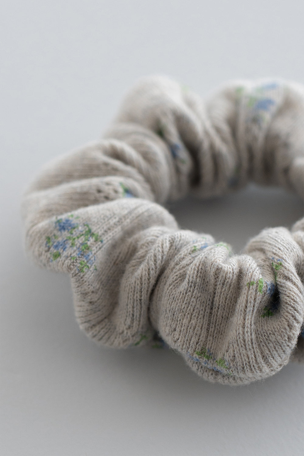 Close-up of pebble green scrunchie with subtle blue flower pattern – Avauma
Close-up of pebble green scrunchie with subtle blue flower pattern – Avauma