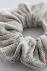 Close-up of pebble green ribbed scrunchie with pastel blue and green floral pattern – Avauma Close-up of pebble green ribbed scrunchie with pastel blue and green floral pattern – Avauma