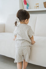 Back view of toddler standing by a sofa, hair tied with scrunchie, wearing Avauma Berry Cream Mellow Days Set Back view of toddler standing by a sofa, hair tied with scrunchie, wearing Avauma Berry Cream Mellow Days Set