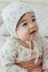 Close-up of a smiling baby in the Cream Floral bodysuit – featuring a cheerful expression and charming floral print Close-up of a smiling baby in the Cream Floral bodysuit – featuring a cheerful expression and charming floral print