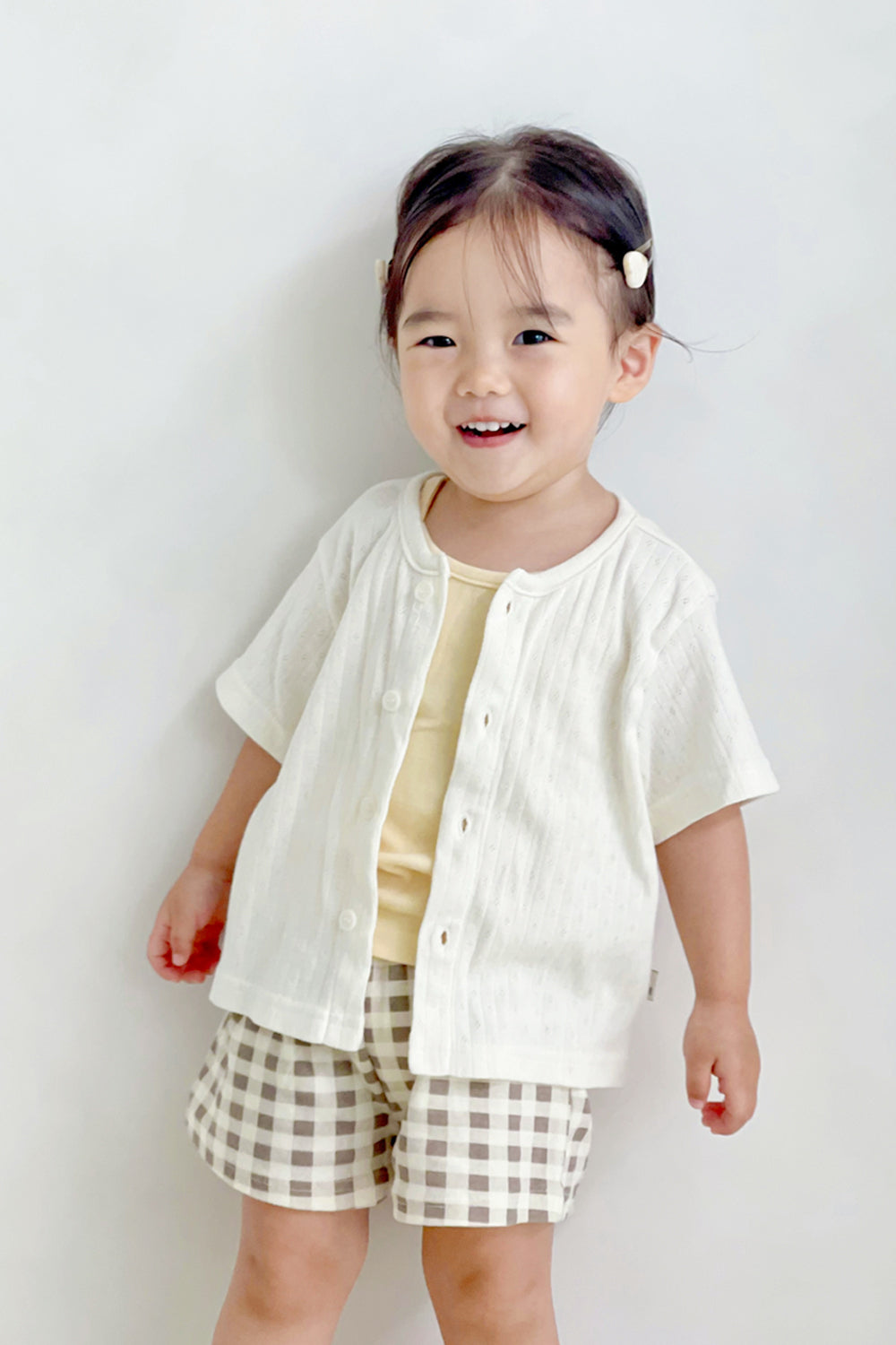 Girl in Avauma butter check set with short-sleeve cardigan – soft layered summer look
Girl in Avauma butter check set with short-sleeve cardigan – soft layered summer look