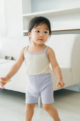 Toddler girl wearing AVAUMA Laila Day sleeveless lilac cream set, standing front view Toddler girl wearing AVAUMA Laila Day sleeveless lilac cream set, standing front view