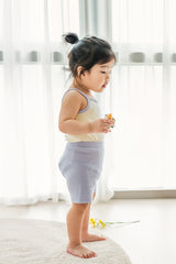 Toddler girl wearing AVAUMA Laila Day sleeveless lilac cream set, side profile Toddler girl wearing AVAUMA Laila Day sleeveless lilac cream set, side profile