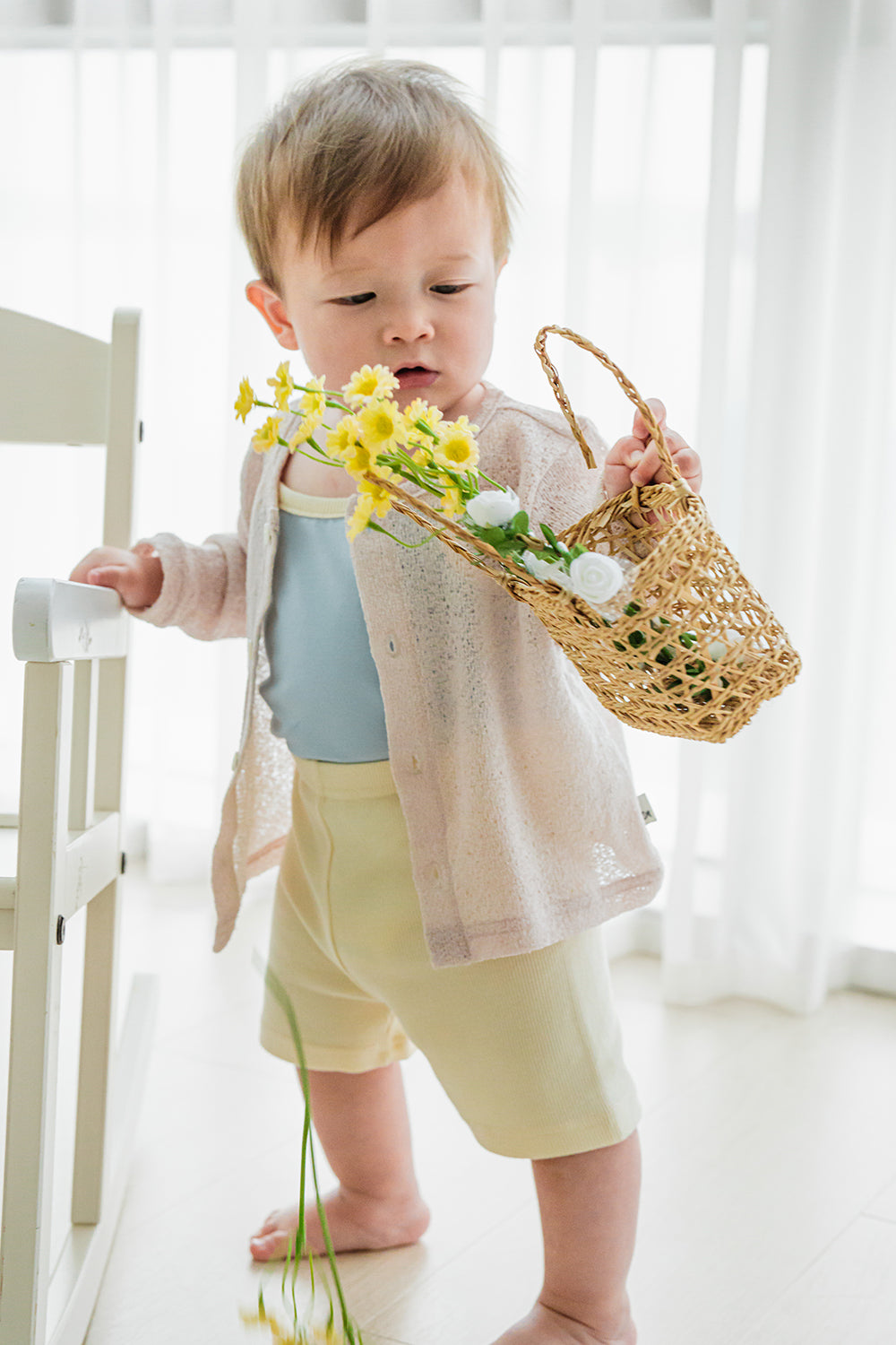 Toddler standing by window holding flowers in Avauma pale lime sleeveless set
 Toddler standing by window holding flowers in Avauma pale lime sleeveless set