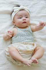 Cute baby wearing Avauma Lily Sleeveless Bodysuit Sage Flower. Infant in a sage green floral print bodysuit paired with plain cream bloomers and a white headband.
Cute baby wearing Avauma Lily Sleeveless Bodysuit Sage Flower. Infant in a sage green floral print bodysuit paired with plain cream bloomers and a white headband.