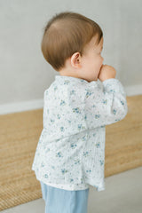 Side view of toddler in Avauma Littleshell forest mint cardigan, standing near a window.
Side view of toddler in Avauma Littleshell forest mint cardigan, standing near a window.