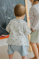 Back view of toddler standing near chalkboard in Avauma Littleshell forest mint cardigan.
Back view of toddler standing near chalkboard in Avauma Littleshell forest mint cardigan.