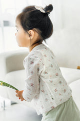 Toddler girl in avauma Rosy Cream Flower Cardigan sitting sideways, holding greenery, wearing light green shorts.
Toddler girl in avauma Rosy Cream Flower Cardigan sitting sideways, holding greenery, wearing light green shorts.