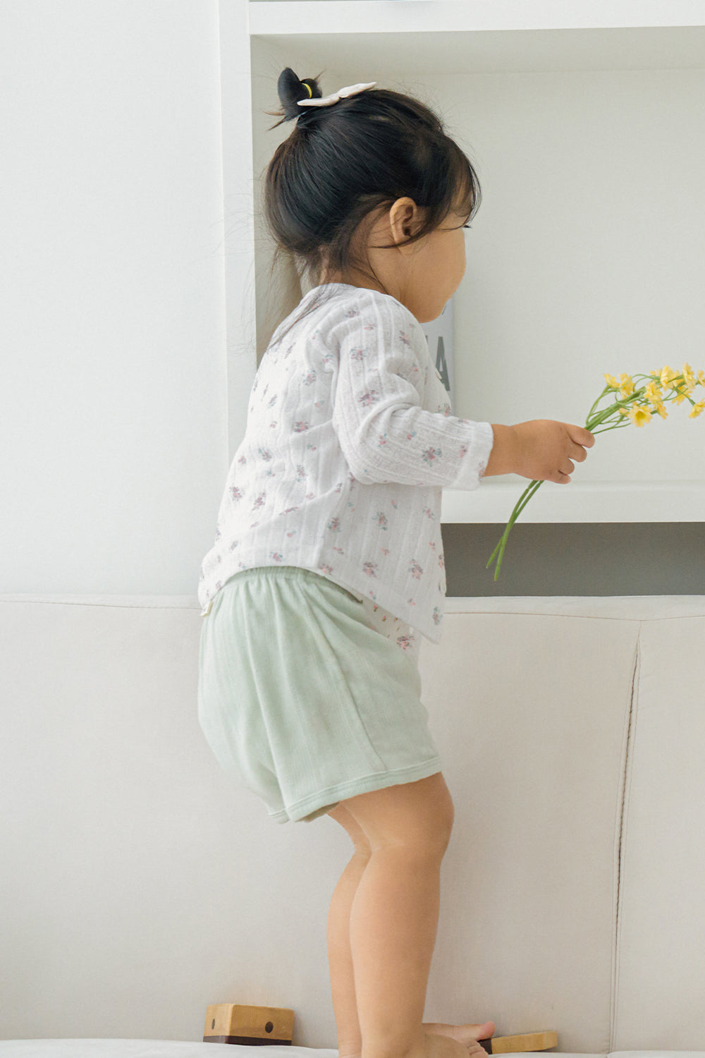 Baby girl in avauma Rosy Cream Cardigan, reaching for yellow flower in cozy home setting.
Baby girl in avauma Rosy Cream Cardigan, reaching for yellow flower in cozy home setting.
