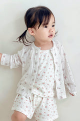 Girl sitting on floor in avauma Rosy Cream Cardigan, holding cardigan open to reveal matching innerwear.
Girl sitting on floor in avauma Rosy Cream Cardigan, holding cardigan open to reveal matching innerwear.