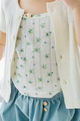 Close-up of toddler wearing Avauma Oat Latte short-sleeve cardigan over a floral-printed inner top.
Close-up of toddler wearing Avauma Oat Latte short-sleeve cardigan over a floral-printed inner top.