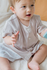 Seated baby model showcasing the ivory Lucent Short Sleeve Cardigan. Ideal for active babies, soft short-sleeve cardigan, infant fashion. Seated baby model showcasing the ivory Lucent Short Sleeve Cardigan. Ideal for active babies, soft short-sleeve cardigan, infant fashion.