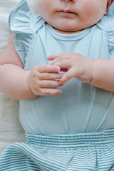 Close-up of baby wearing Avauma Mellow Stripe Set Aquamint. Infant's hands and upper body in a soft blue striped outfit. Close-up of baby wearing Avauma Mellow Stripe Set Aquamint. Infant's hands and upper body in a soft blue striped outfit.