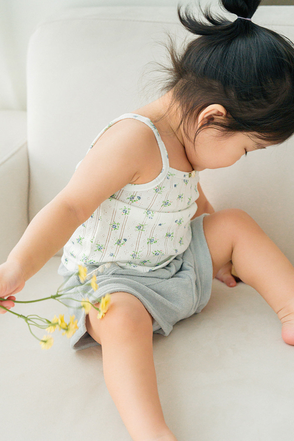 Toddler girl in Avauma Green Tea Milk shorts, sitting on sofa with yellow flower in hand
Toddler girl in Avauma Green Tea Milk shorts, sitting on sofa with yellow flower in hand