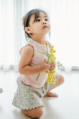 Toddler kneeling in Avauma baked peach sleeveless top with floral shorts, holding yellow flowers – cute summer moment Toddler kneeling in Avauma baked peach sleeveless top with floral shorts, holding yellow flowers – cute summer moment