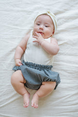 Avauma Summer Picot Sleeveless Bodysuit Buttermilk product shot. Lay-flat of white ribbed baby romper with small bow on a clean background.
Avauma Summer Picot Sleeveless Bodysuit Buttermilk product shot. Lay-flat of white ribbed baby romper with small bow on a clean background.