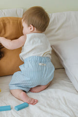 Back view of baby in Avauma Sunny Stripe Pants Blueberry Powder. Infant crawling, showcasing the light blue striped shorts with the avauma label.
Back view of baby in Avauma Sunny Stripe Pants Blueberry Powder. Infant crawling, showcasing the light blue striped shorts with the avauma label.