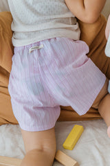 Toddler wearing Avauma Sunny Stripe Pants Lotus Pink. Child's back view showcasing light pink ribbed shorts with a subtle stripe pattern.
Toddler wearing Avauma Sunny Stripe Pants Lotus Pink. Child's back view showcasing light pink ribbed shorts with a subtle stripe pattern.