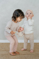 Two baby girls in Avauma sleepwear – Soft Berry floral pajama and cream baby outfit
 Two baby girls in Avauma sleepwear – Soft Berry floral pajama and cream baby outfit