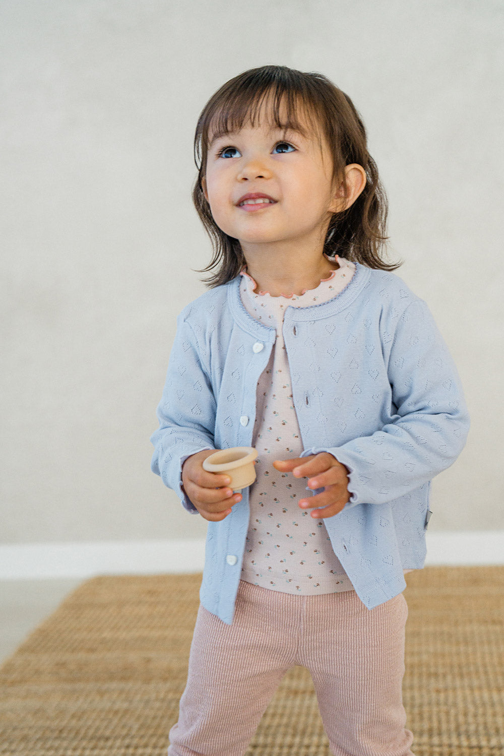 Toddler girl in Avauma Soft Berry pajama layered with a pastel blue cardigan – cozy baby girl look
 Toddler girl in Avauma Soft Berry pajama layered with a pastel blue cardigan – cozy baby girl look