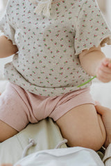 avauma breeze garden set oatberry cream, close-up of floral print baby shirt and pink cotton shorts, soft ribbed texture
avauma breeze garden set oatberry cream, close-up of floral print baby shirt and pink cotton shorts, soft ribbed texture