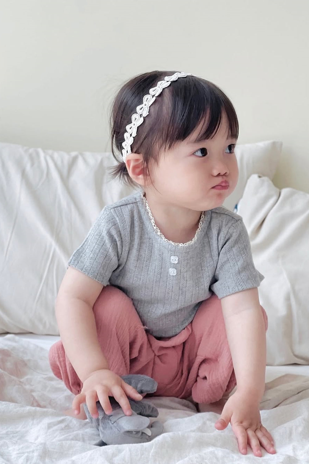 Girl sitting on bed in Avauma Breeze Jogger Pants, rose wood color, paired with gray short-sleeve top. Girl sitting on bed in Avauma Breeze Jogger Pants, rose wood color, paired with gray short-sleeve top.