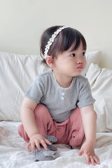 Girl sitting on bed in Avauma Breeze Jogger Pants, rose wood color, paired with gray short-sleeve top. Girl sitting on bed in Avauma Breeze Jogger Pants, rose wood color, paired with gray short-sleeve top.