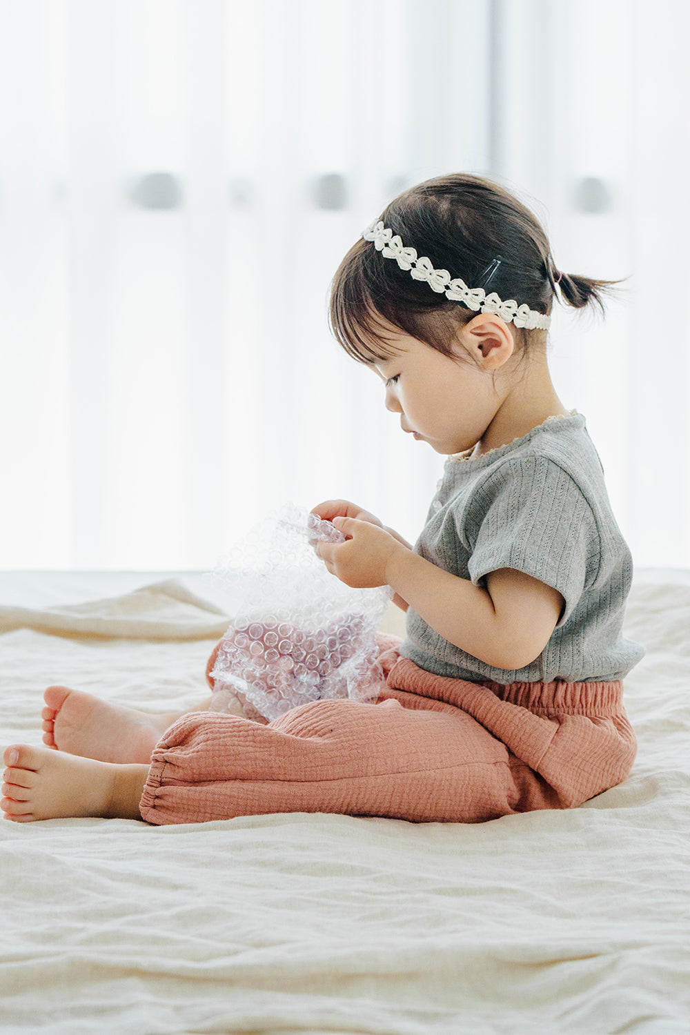 Child seated in Avauma Breeze Jogger Pants in rose wood, with airy fit and soft cotton texture. Child seated in Avauma Breeze Jogger Pants in rose wood, with airy fit and soft cotton texture.