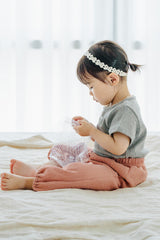 Child seated in Avauma Breeze Jogger Pants in rose wood, with airy fit and soft cotton texture. Child seated in Avauma Breeze Jogger Pants in rose wood, with airy fit and soft cotton texture.