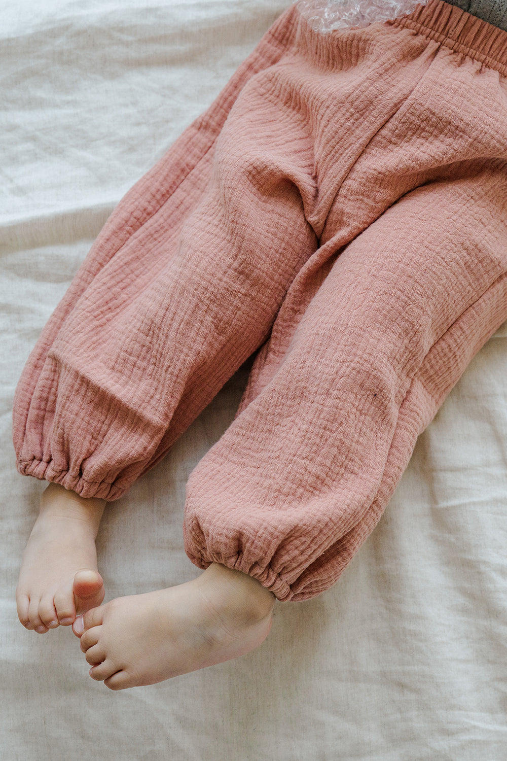 Close-up of Avauma Breeze Jogger Pants in rose wood color, showing gauze texture and ankle cuffs. Close-up of Avauma Breeze Jogger Pants in rose wood color, showing gauze texture and ankle cuffs.