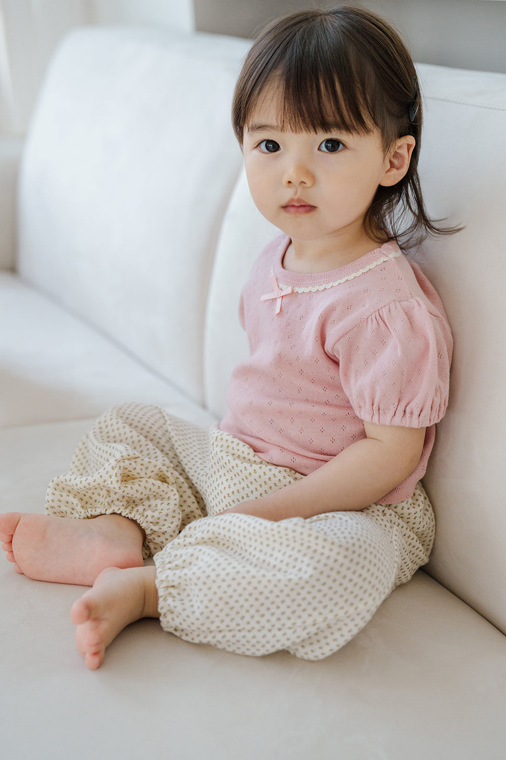 Girl sitting in Avauma Breeze Jogger Pants - roseberry cream, with a soft pink blouse. Girl sitting in Avauma Breeze Jogger Pants - roseberry cream, with a soft pink blouse.