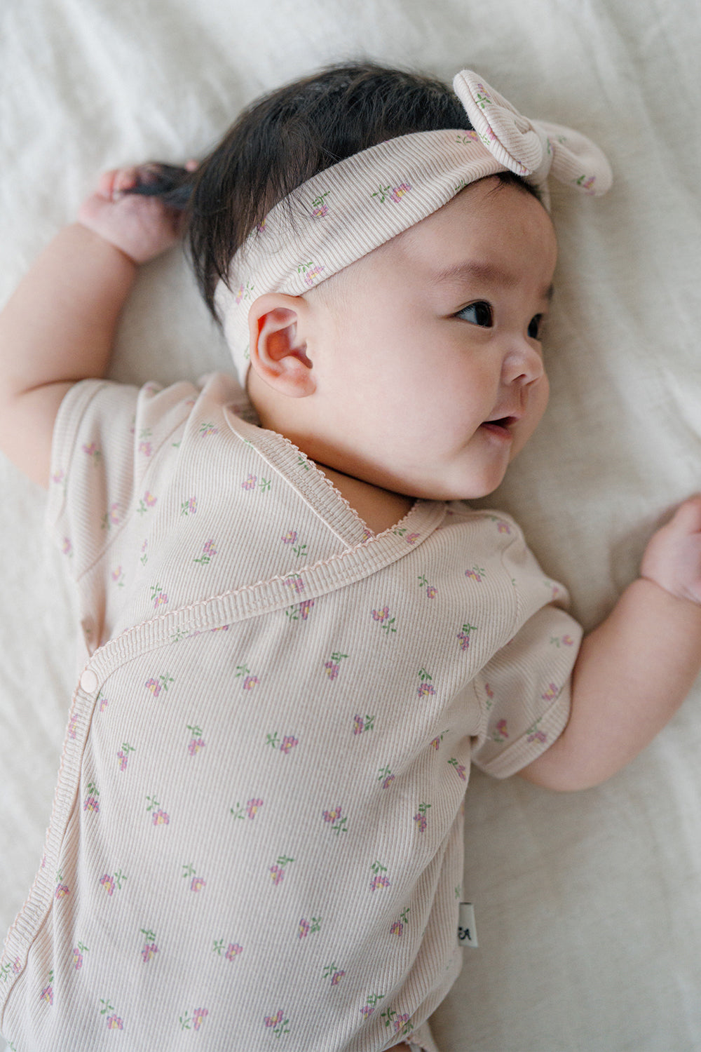 Side View of Baby Wearing Avauma Clare Peach Cream Short Sleeve Bodysuit, Delicate Floral Design
Side View of Baby Wearing Avauma Clare Peach Cream Short Sleeve Bodysuit, Delicate Floral Design