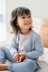 Smiling toddler girl in Avauma Peach Cloud ribbed pajamas – soft and breathable cotton baby sleepwear
 Smiling toddler girl in Avauma Peach Cloud ribbed pajamas – soft and breathable cotton baby sleepwear