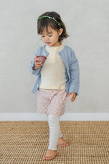 Toddler walking while wearing Avauma cream pink floral skirt leggings and holding a toy cup Toddler walking while wearing Avauma cream pink floral skirt leggings and holding a toy cup