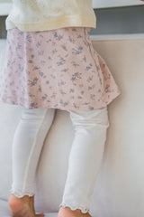 Close-up of Avauma flower skirt leggings in cream pink, focusing on floral fabric and stitching Close-up of Avauma flower skirt leggings in cream pink, focusing on floral fabric and stitching