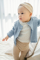Baby girl in Avauma Haze Heart cardigan with beige headband and ribbed leggings, stylish baby clothes Baby girl in Avauma Haze Heart cardigan with beige headband and ribbed leggings, stylish baby clothes