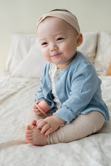 Smiling baby in Avauma blue cotton cardigan, cozy baby outfit with heart knit details for girls and boys Smiling baby in Avauma blue cotton cardigan, cozy baby outfit with heart knit details for girls and boys