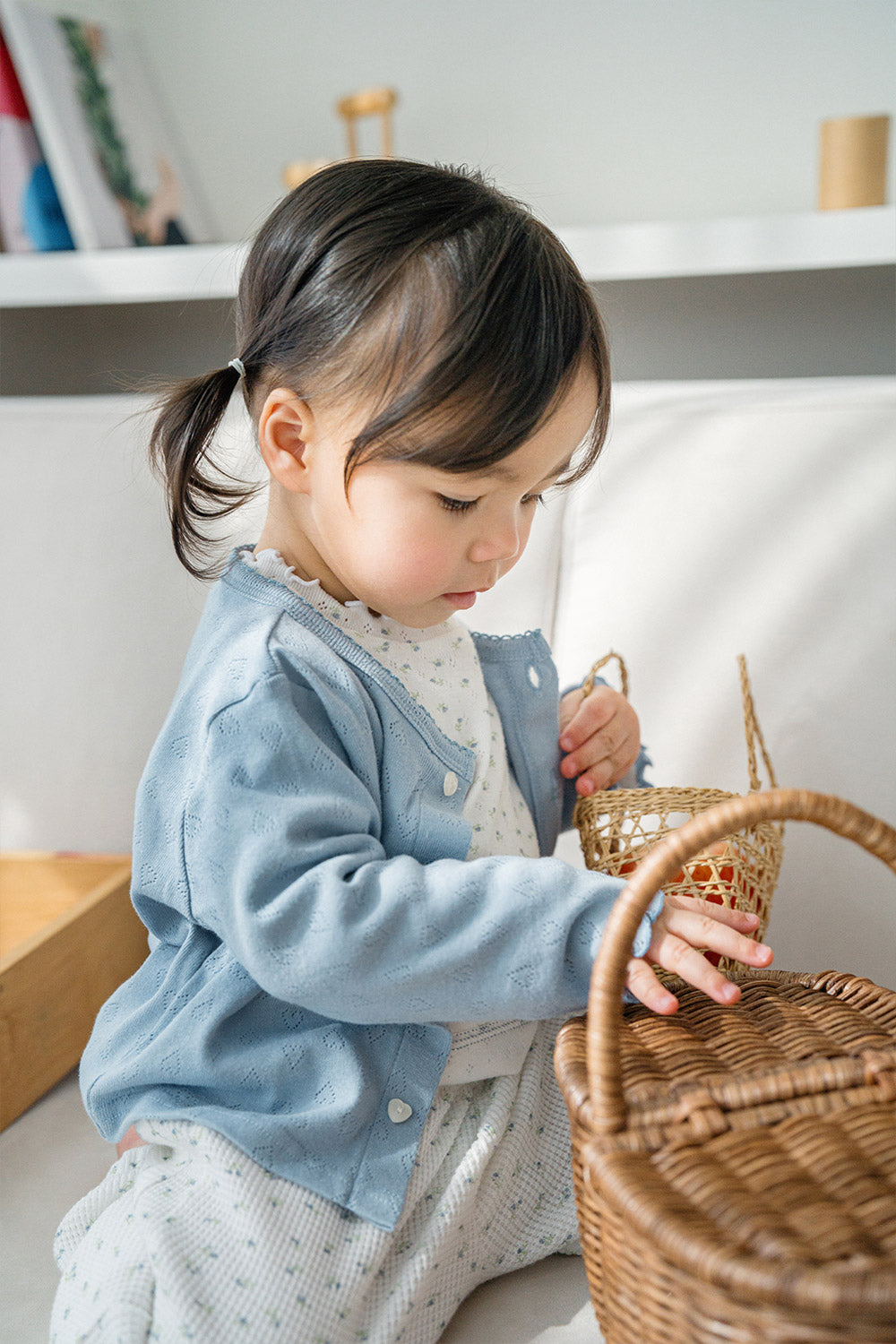 Side view of toddler girl in Avauma Haze Heart baby cardigan, comfy layering piece for baby outfits Side view of toddler girl in Avauma Haze Heart baby cardigan, comfy layering piece for baby outfits